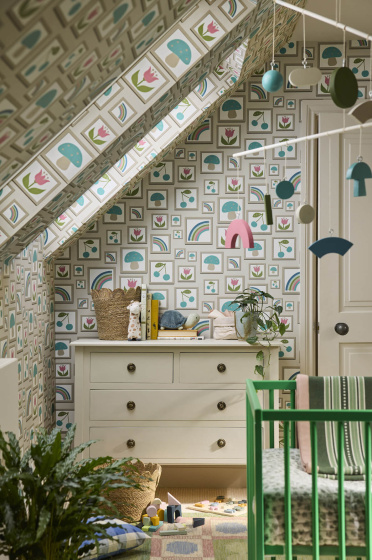 Nursery featuring neutral photo frame print wallpaper (Balance - Portland Stone) with a dresser, green crib and a plant.