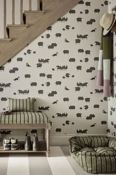 Hallway space featuring neutral dog and sheep print wallpaper (Nip & Lassie - Slaked Lime - Dark) with a dog sat in a bed on the right and stairs to the left.