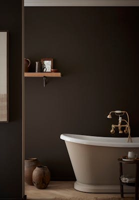 Bathroom colour drenched in deep brown shade 'Chocolate Colour' with a contrasting neutral (Rolling Fog - Dark) bath tub with gold taps.