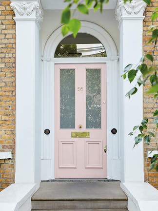 A front door painted in the light pink shade 'Dorchester Pink - Mid' with a white door frame.