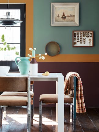 Dining room with a contrasting wall, with the lower half painted in Cordoba and the upper wall in Pleat.