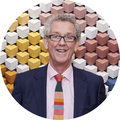 David Mottershead, Founder & MD Little Greene, standing in front of a wall comprised of multi-colored cubes.