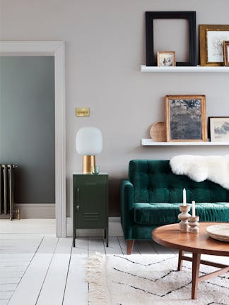 Velvet forest green sofa in front of a light grey (French Grey) wall and on top of bright white wood flooring in Loft White.