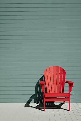 Exterior panelled wall in green blue shade (Pleat) with a bright Atomic Red chair and neutral Cool Arbour panelled floor.