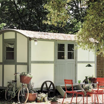 Yard with red garden furniture and a neutral (Acorn - Mid) shed with muted green (Windmill Lane) wood trim and door.