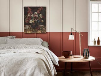 Bedroom with a light grey (French Grey) upper wall and a terracotta red 'Tuscan Red' lower wall behind a bed.