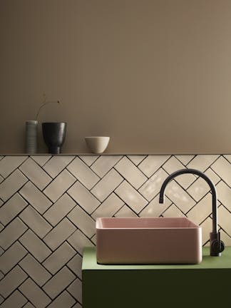 Bathroom  painted in warm neutral Rolling Fog with off white tiles underneath and a pink and green color block sink.