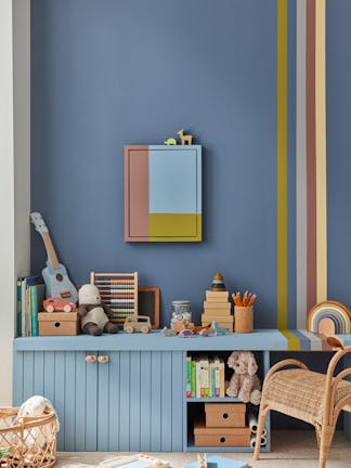 Child's playroom painted in dark blue (Juniper Ash) with multi colored stripes on the right, and toys placed on top of a unit.