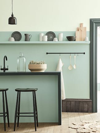 Kitchen space in varying shades of Aquamarine with a breakfast bar and stools on a wooden floor.