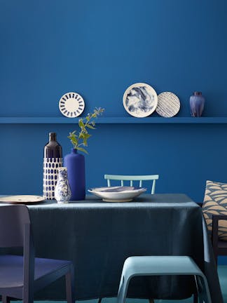 Dining room color drenched in rich blue 'Mazarine' with a dining room table and chairs.