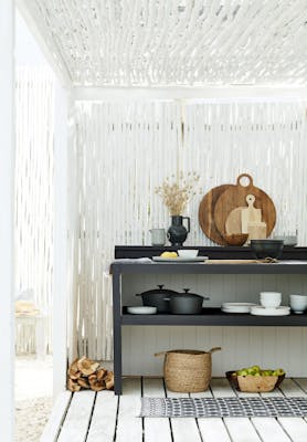 Outdoor kitchen area made from bamboo painted in bright white 'Loft White' with a contrasting black kitchen unit.