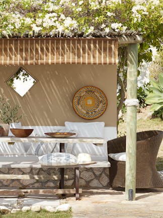 Outdoor dining area painted in the neutral color Lute, with a cushioned seating area painted in off-white Flint.