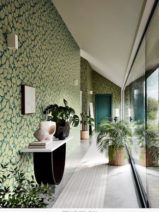 Hallway featuring a wall with blue-green leaf-printed wallpaper (Beech Nut Florence) and floor-to-ceiling windows opposite.