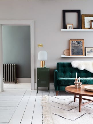 Velvet forest green sofa in front of a light grey (French Grey) wall and on top of bright white wood flooring in Loft White.