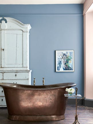 Bathroom featuring light blue wallpaper with thin stripes (Cavendish Stripe - Brush Blue) and a copper freestanding bathtub.