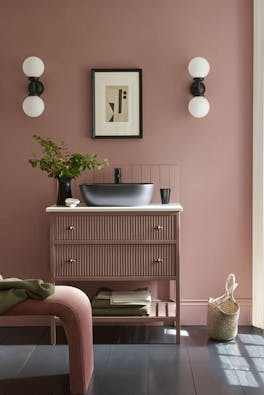 Bathroom sink area painted in blush pink shade 'Hellebore'  with darker pink 'Blush' on the vanity unit and a black sink.