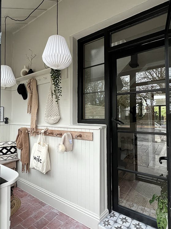 Home entrance with beige walls and paneling (Slaked Lime - Deep), alongside contrasting door and window frames in Jack Black.