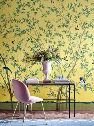 Home study with a bright yellow floral and bird wallpaper (Belton Scenic - Sunbeam) with a desk and chair placed in front.