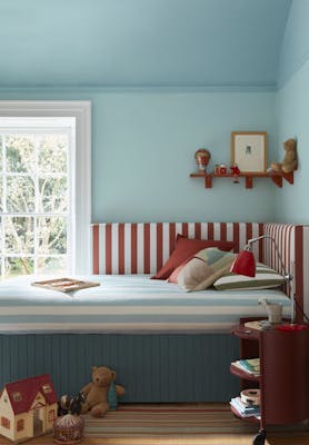 Children's bedroom painted in three shades of light blue ('Brighton', 'Sky Blue' and 'Etruria') with a striped blue, red and white comforter on the bed and toys on the floor.