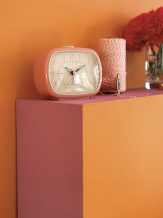 Close-up of a bright orange (Marigold) wall, along with a bedhead in bright pink (Leather) and orange (Marigold) colors.