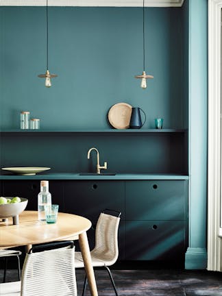 Kitchen painted in blue green (Tea with Florence) and dark green (Harley Green) with a round wooden table and chairs.