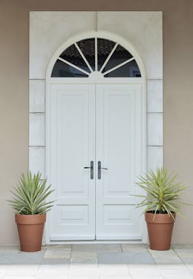 Front door entrance in bright white (Shirting) with matching surround and contrasting neutral back wall and two plant pots.