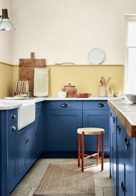 Kitchen with deep indigo (Woad) kitchen units and contrasting yellow tiles and upper wall.