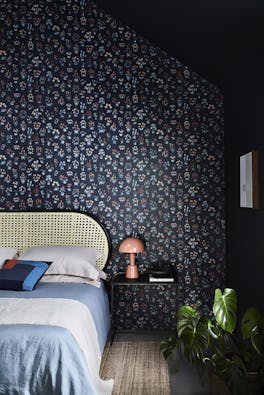 Bedroom with blue small floral wallpaper 'Millefleur - Knight' and deep blue 'Basalt' walls.