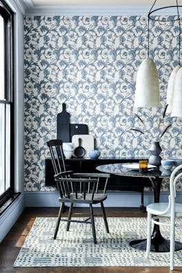 Dining room with a blue and off-white Georgian style wallpaper (Stag Trail - Sky) with a table and chairs.