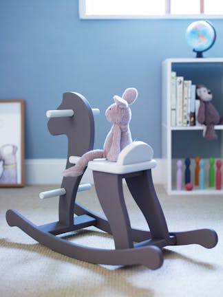 Nursery featuring a wooden rocking horse, light blue walls and white baseboards.