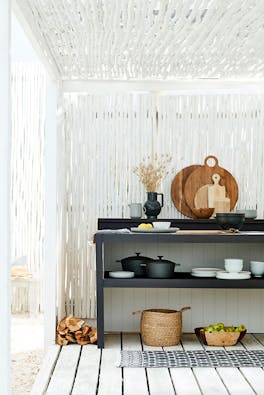 Outdoor kitchen area made from bamboo painted in bright white 'Loft White' with a contrasting black kitchen unit.