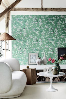 Living area with green printed floral and bird wallpaper (Massingberd Blossom - Verditer), cream sofa and ceiling beams.