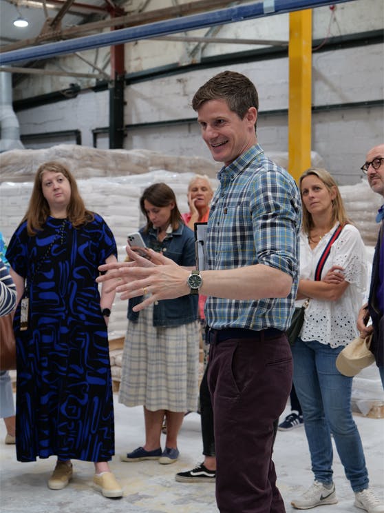 Man wearing a checked shirt talking to our event guests.