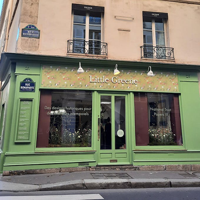 The Pea Green exterior of the Little Green Paris showroom located on the ground floor of a multi-storey building.