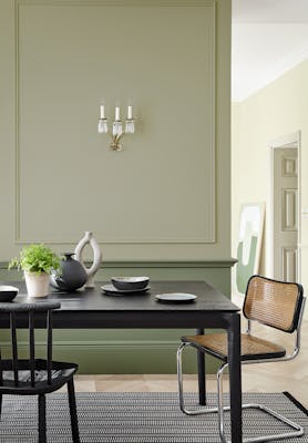 Dining space in neutral green 'Book Room Green' with a 'Sage Green' lower wall, and black dining room table and chairs.