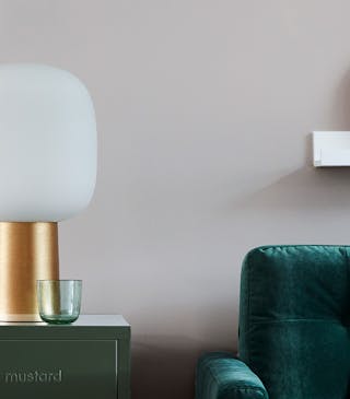 Velvet forest green sofa in front of a light grey (French Grey) wall.