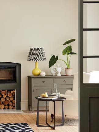 Neutral living space painted in 'Portland Stone' with grey drawers, fireplace and an armchair.