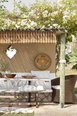 Outdoor dining area painted in the neutral color Lute, with a cushioned seating area painted in off-white Flint.