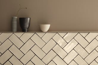 Wall painted in the neutral brown shade 'Rolling Fog' on the upper half, and the lower half comprised of cream tiles.