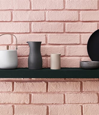 Kitchen with pink (Confetti) brickwork on the walls, a black shelf, black (Lamp Black) cupboards and a wooden counter top.