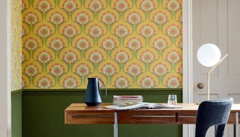 Home study space with the lower wall painted in deep green and yellow floral wallpaper (Hencroft - Punch) on the upper wall.