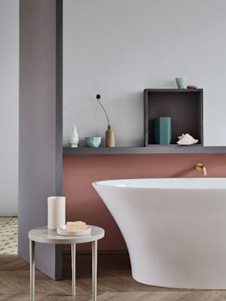 A bathtub in front of a wall with the lower half in a muted pink (Blush) and the upper wall in grey (Gauze - Dark).