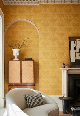 Living room with yellow floral wallpaper (Dahlia Scroll - Giallo) with a chair, cabinet and fireplace,