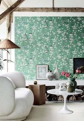 Living area with green printed floral and bird wallpaper (Massingberd Blossom - Verditer), cream sofa and ceiling beams.