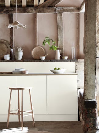 Kitchen space with wooden pillars and ceiling with off white (Flint) units and a wooden bench.