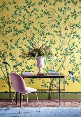 Home study with a bright yellow floral and bird wallpaper (Belton Scenic - Sunbeam) with a desk and chair placed in front.