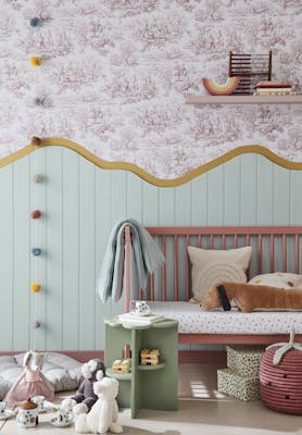 Child's playroom with ‘Lovers' Toile – Blush’ on the upper wall and ‘Aquamarine – Mid’ on the lower wall with a pink bench and toys on the floor.