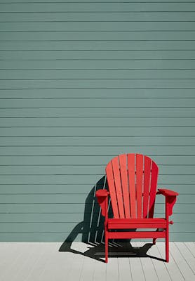 Exterior panelled wall in green blue shade (Pleat) with a bright Atomic Red chair and neutral Cool Arbour panelled floor.