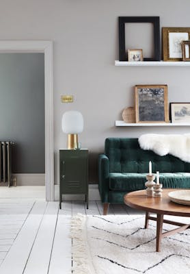 Living room painted in pale French Grey paint, with emerald green furniture