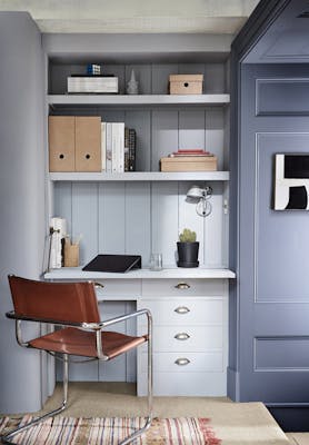 Home office space painted in cool neutral 'Obscura' and dark blue 'Juniper Ash', with a desk and office chair. 